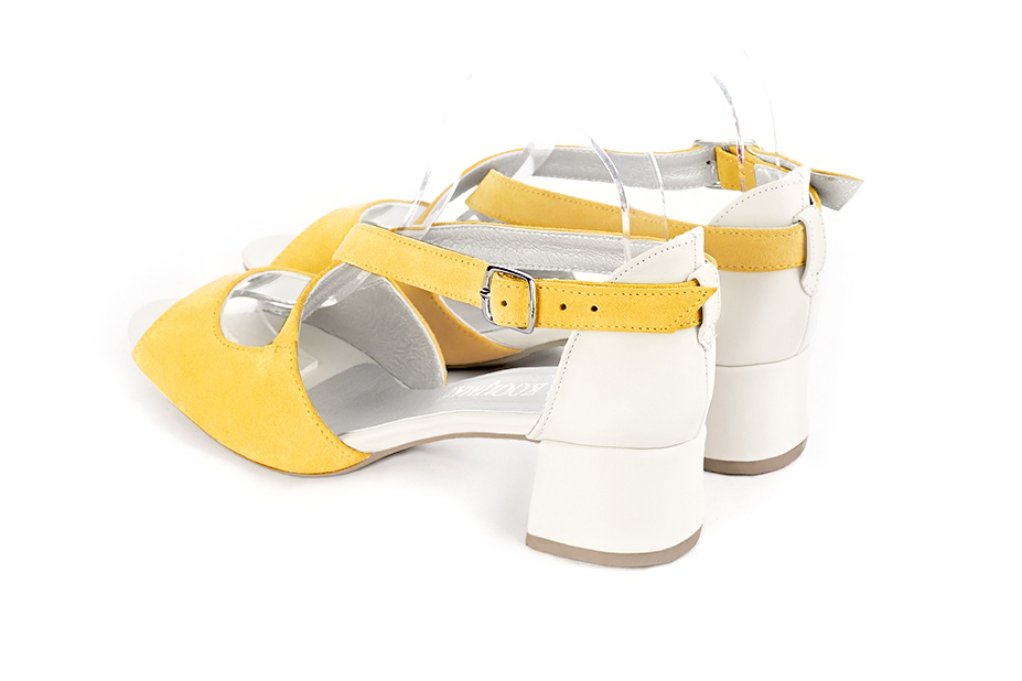 Women's yellow and off white elegant sandals closed at the back with crossed straps. Round toe. Low flare heels - Rear view